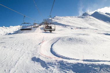 Telesiyej, sandalye, Kayak, kışın güneşli bir kayakçı ve snowboard taşıyan kablo Asansör