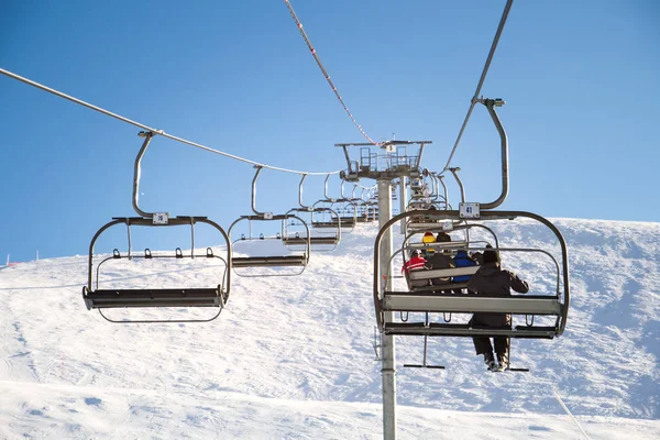 Remonte, teleférico con esquiadores en un día soleado en la estación de esquí, montañas — Foto de Stock