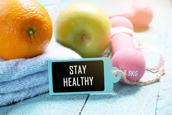 Fitness ve sağlık kavramı. Fitness Ekipmanları, beslenme gıda ve ahşap etiketi ile sağlıklı kalmak ahşap arka plan üzerinde yazılı.