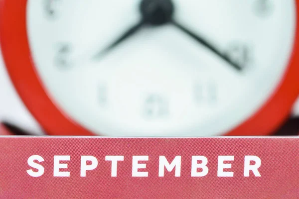 Word of September on a background of clock dial