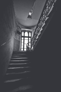 Eski bir penceresi olan garip bir verandada kasvetli bir merdiven..