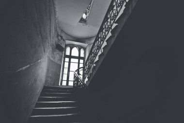 Eski bir penceresi olan garip bir verandada kasvetli bir merdiven..