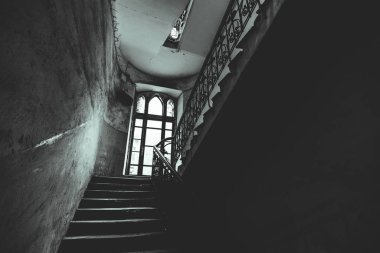 Eski bir penceresi olan garip bir verandada kasvetli bir merdiven..