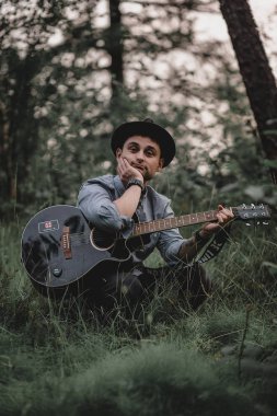 Ormanda gitar çalan adam.