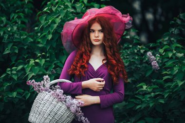 girl in a dress among lilacs