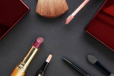 Siyah karton arka planda kozmetik aksesuarlar. Üst görünüm