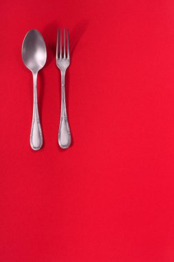Kırmızı desenli arka planda bulunan eski gümüş çatal bıçak takımı. Nadir bileşim. 