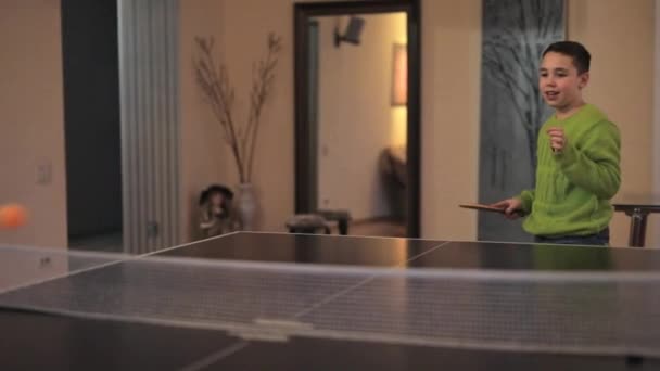 Niño solo juega tenis de mesa en la habitación — Vídeo de stock