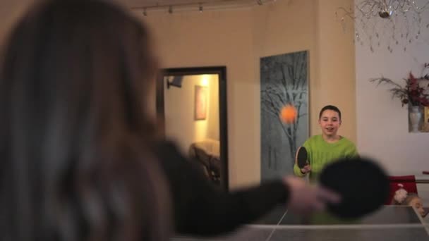 Chłopiec sam gra w tenisa stołowego w pokoju — Wideo stockowe