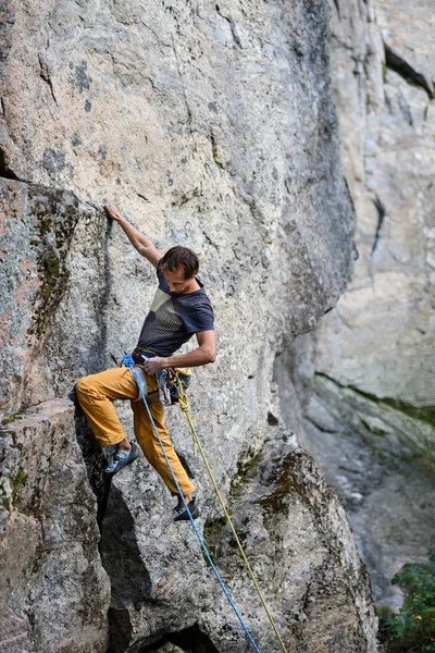 Bergsteiger, der eine herausfordernde Klippe erklimmt. Extremsport Klettern. Freiheit, Risiko, Herausforderung, Erfolg. — Stockfoto