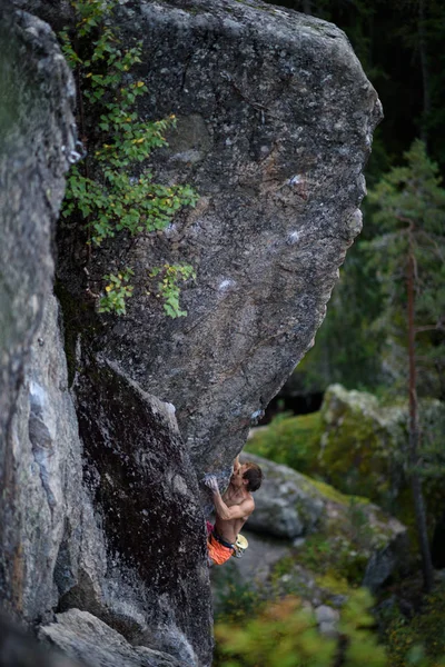 Männlicher Bergsteiger kämpft sich an einen herausfordernden Überhang. Extremsportklettern. — Stockfoto
