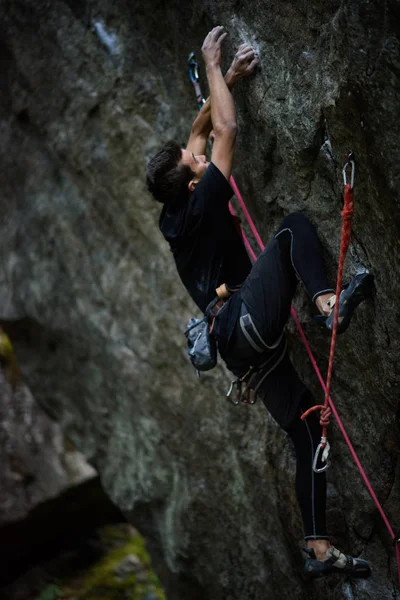 Escalador escalando un acantilado desafiante. Escalada deportiva extrema. Libertad, riesgo, desafío, éxito. — Foto de Stock