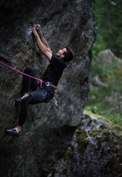 Escalador en un acantilado. Escalada de plomo en un acantilado colgante. Deportes extremos al aire libre . — Foto de Stock