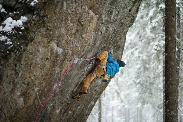 Deportes de invierno únicos. Escalador de rocas en un ascenso desafiante. Escalada extrema . — Foto de Stock