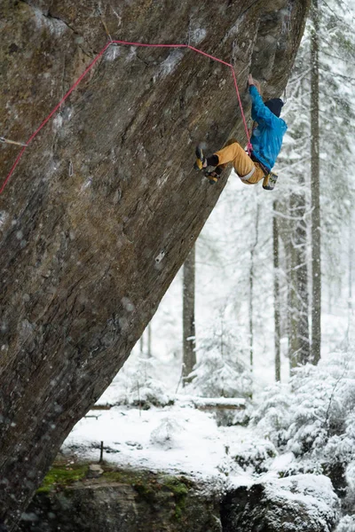 Deportes de invierno al aire libre. Escalador escalando un acantilado desafiante. Escalada deportiva extrema . — Foto de Stock