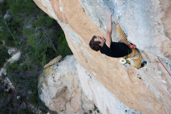 Rock climber, professional athlete, climbing in Siurana rocks, Spain. Extreme sports. 