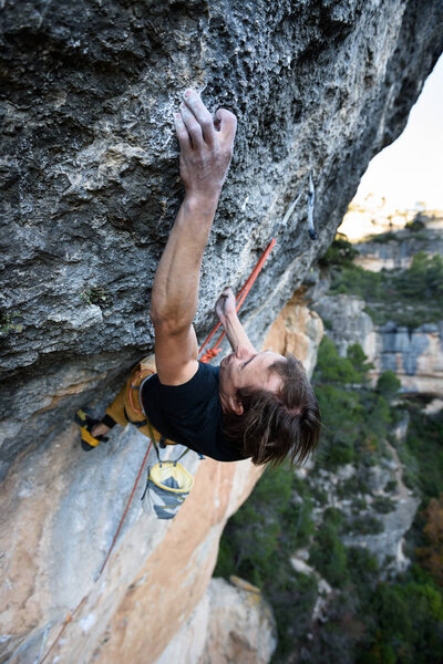 Outdoor activity. Extreme rock climbing lifestyle. Male rock climber od a cliff wall. Siurana, Spain.