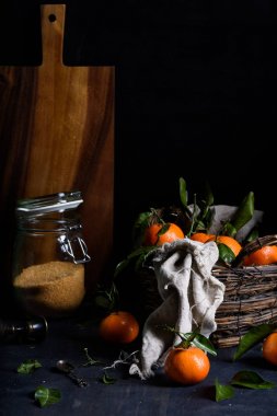 Taze turuncu meyveler, koyu mavi zemin üzerine bir sepet içinde toplandı. Yakın çekim. 