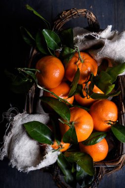 Olgun mandalina, ahşap arka plan üzerinde bir sepet içinde meyvelerin taze hasat. Üstten Görünüm. 