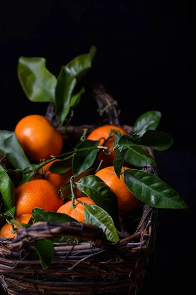 Mandarinas, frutas naranjas en una canasta, fondo negro. De cerca. . — Foto de Stock