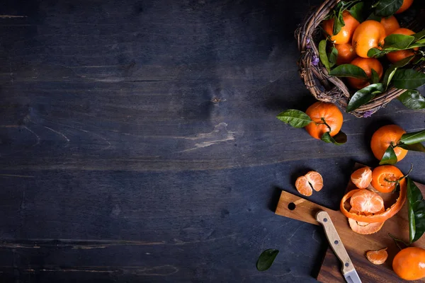 Frutas anaranjadas orgánicas saludables sobre fondo de madera oscura. Vista superior, espacio de copia — Foto de Stock