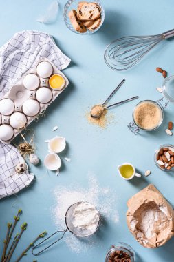 Maddeler mavi mutfak tezgah üzerinde pişirme fırın arka plan. Un, yumurta, şeker ve badem fındık. Üstten Görünüm.