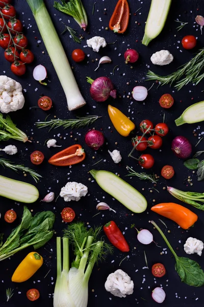 Verduras coloridas y especias sobre fondo negro. Mostrar productos. Alimentos vegetarianos orgánicos saludables. Diseño del mercado de agricultores. Vista superior . — Foto de Stock