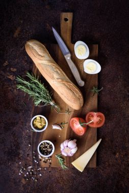 Baget sandviç malzemeler - peynir, yumurta, domates, hardal ahşap tahta üzerinde. Üstten Görünüm, kopya alanı.