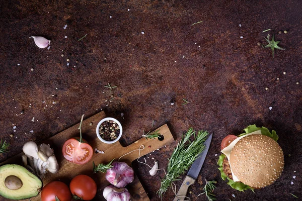 Deliciosa hamburguesa de queso con empanada de ternera, queso, lechuga fresca, champiñones y tomate en un bollo fresco con semillas de sésamo en una mesa rústica. Copiar espacio, arriba . — Foto de Stock