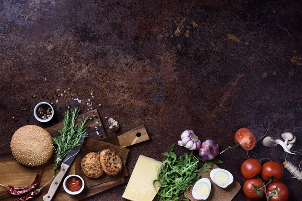 Hamburguesa fresca casera en mesa de servir oscura con carne de res, tomates, queso y huevos sobre fondo oscuro. Vista superior, espacio de copia . — Foto de Stock