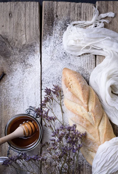 Baguette di pane appena sfornato e miele. Uno spuntino croccante. Vista dall'alto, copia spazio . — Foto Stock