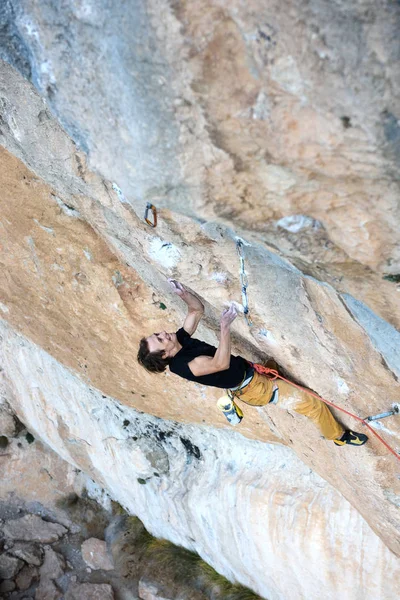 Bergsklättraren klättrar uppför en utmanande klippa. Extrem klättring. Frihet, risk, utmaning, framgång. Idrott och aktivt liv. — Stockfoto
