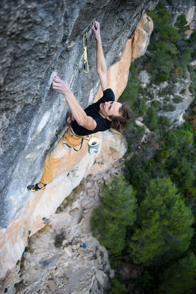 Rock climber ascending a challenging cliff. Extreme sport climbi