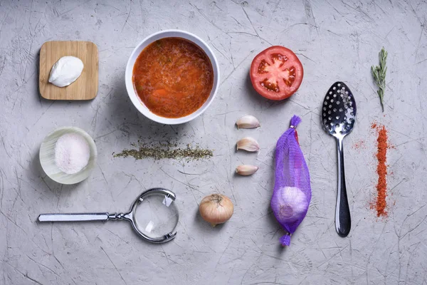 Kook ingrediënten op grijze achtergrond, tomatensoep met kruiden. — Stockfoto