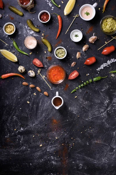 Salsas y salsas, ingredientes y bocadillos sobre fondo de mesa desordenado — Foto de Stock