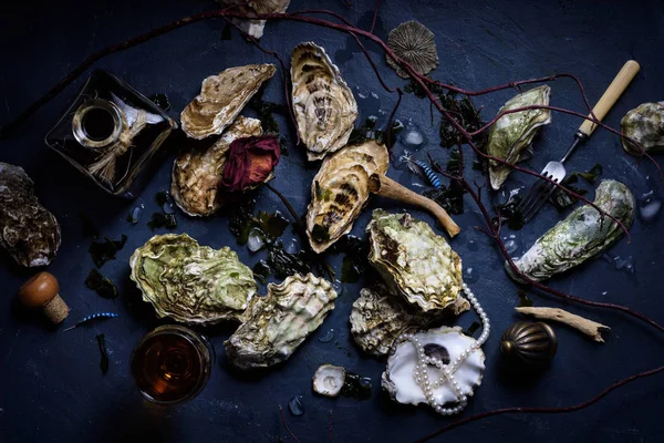 Koyu arka plan üzerine düzenlenmiş şarap ile çiğ istiridye.