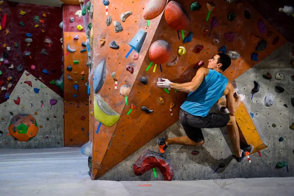 Homem alpinista em bouldering gym.Indoor exercício de treino . — Fotografia de Stock