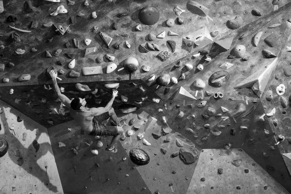 Exercício de treino. Esportivo macho formação interior, escalando uma parede de pedra . — Fotografia de Stock