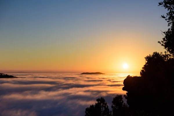 Naturs kön solnedgång ovanför molnen och bergen. Hav av moln landskap. — Stockfoto