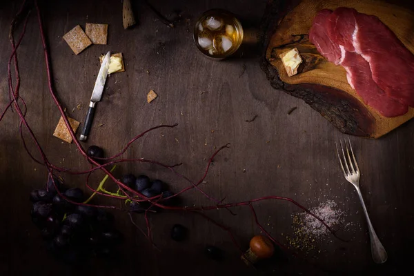 Κρέας, μοσχαρίσια μπριζόλα σε σκούρα ξύλινη σανίδα. Μαγείρεμα φόντο, — Φωτογραφία Αρχείου