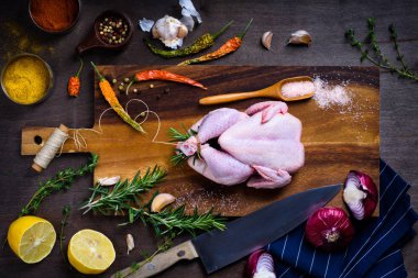 Çiğ tavuk, otlar ve baharatlar kesme tahtası üzerinde. Gıda katkı maddeleri