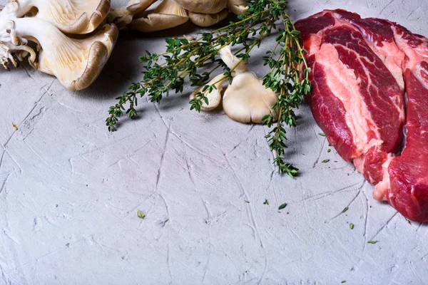 Bifes crus, ervas e ingredientes de cozinha, cozimento de alimentos . — Fotografia de Stock