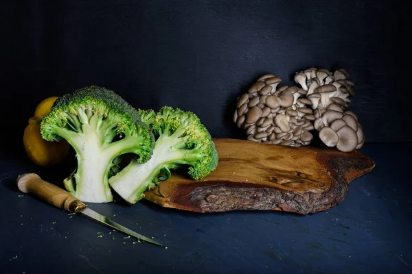 Ingredientes en tabla de cortar de madera, brócoli con setas . — Foto de Stock