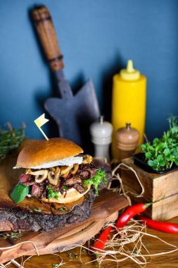 Mantarlı ızgara sığır burger ve tahta tahtada servis edilen peynir. Boşluğu kopyala.