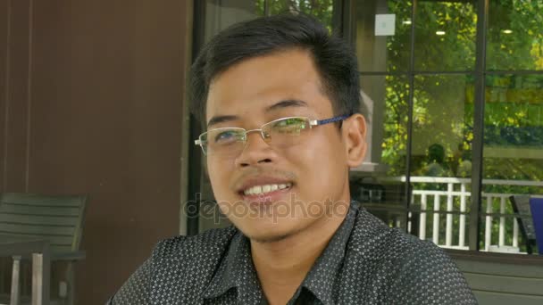 MCU de um jovem asiático masculino profissional sorrindo para a câmera com uma sensação de sucesso — Vídeo de Stock