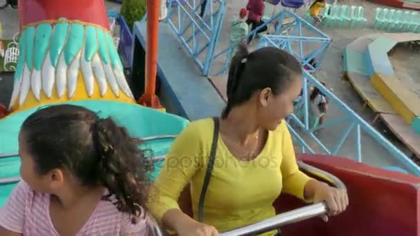 Een multiculturele Aziatische familie ritten op een schommel amusement park ride samen — Stockvideo