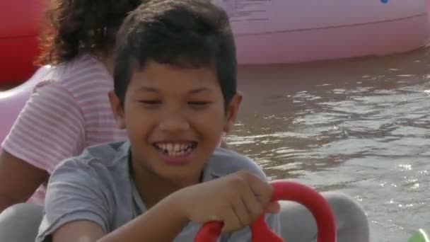 金边，柬埔寨-2017 年 5 月 17 日： 亚洲的哥哥和姐姐骑一只巨型的天鹅游乐园里的过山车 — 图库视频影像