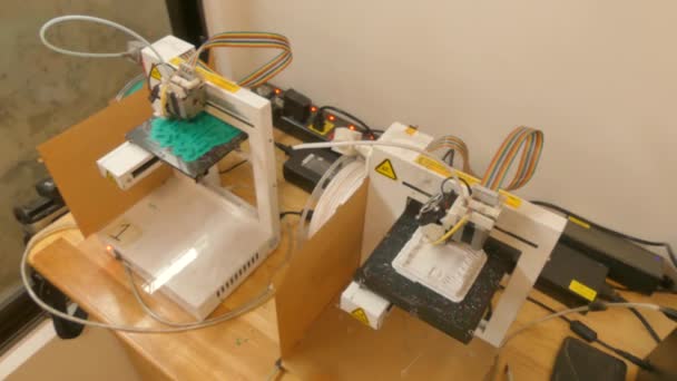 Overhead 2-shot van een paar van 3D-printers in werking in een maker-ruimte naaiatelier la — Stockvideo