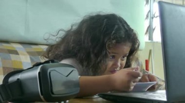 Orta yakından bir kase erişte yemek yerken bir video izlerken çok kültürlü Asya kız; bir Vr kulaklık yakındadır