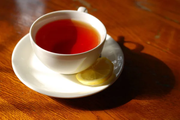 Черный чай с ломтиком лимона — стоковое фото